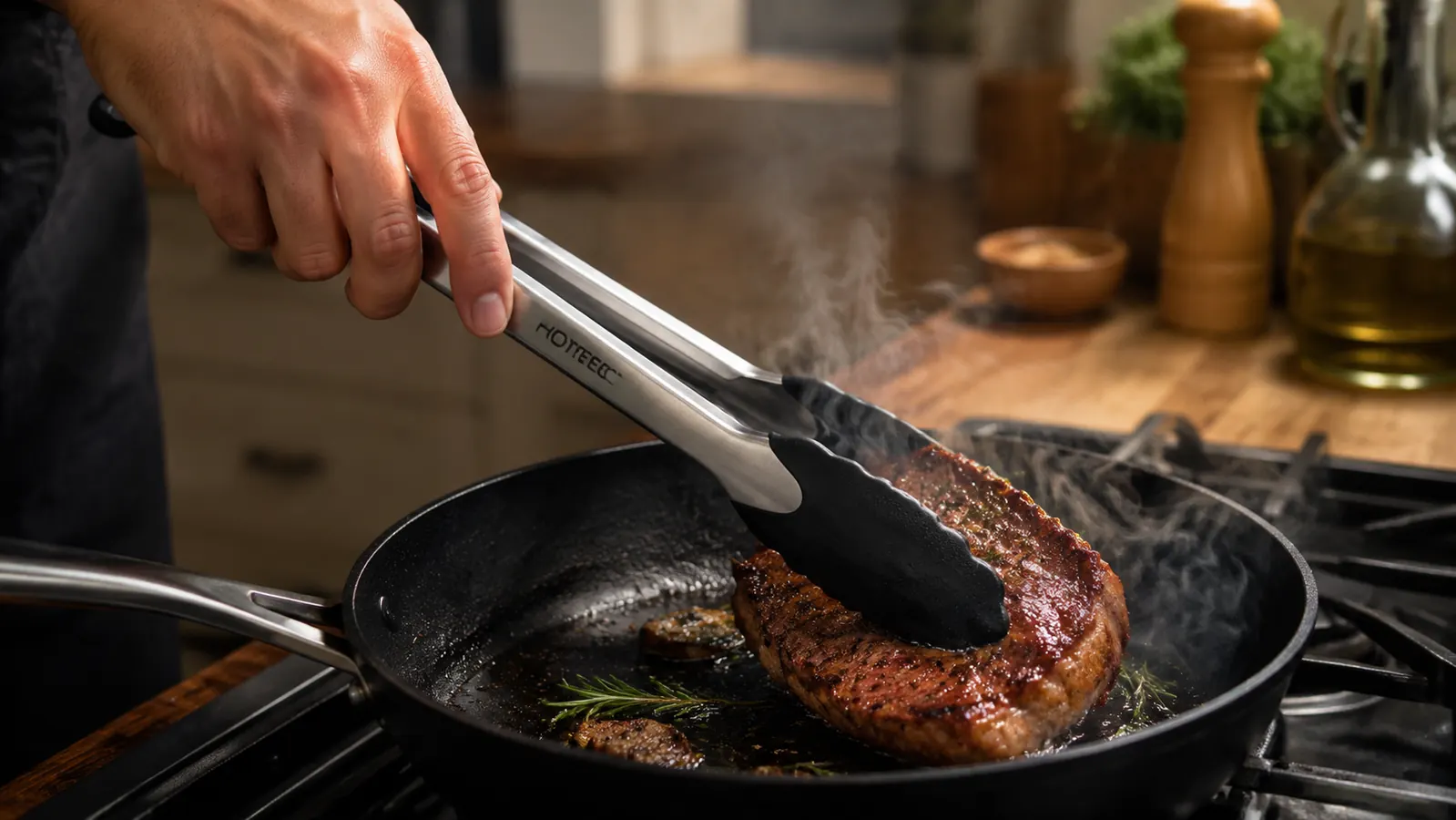 A hand using the 12 inch locking tongs to flip a chicken thigh in a stainless steel skillet on the stovetop